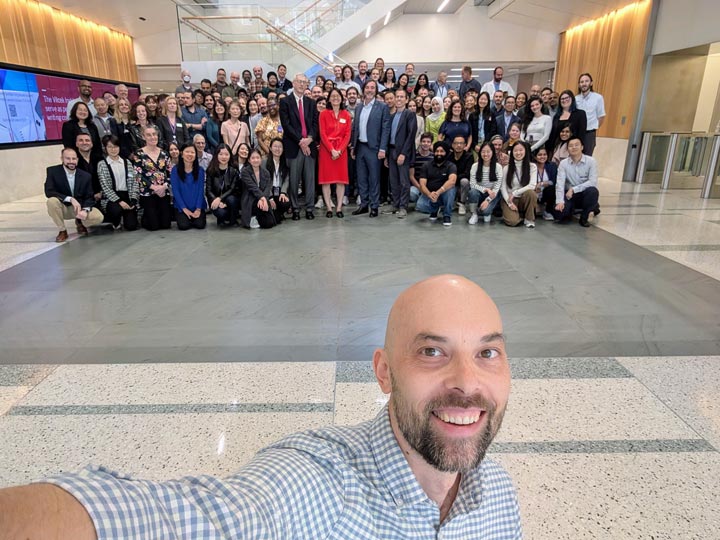 Photo: Pawel with the research team assembled in the background.